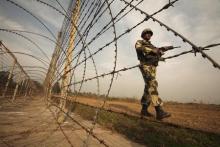 An Indian Border Security Force (BSF) soldier patrols near the fenced border with Pakistan in Suchetgarh, southwest of Jammu in this January 14, 2013 file picture. PHOTO BY REUTERS/Mukesh Gupta