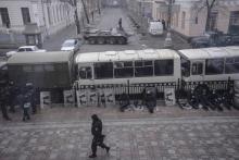 Interior ministry soldiers sit behind buses parked outside the parliament building in Kiev
