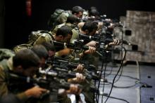 Israeli soldiers respond with laser-firing rifles to a simulated Palestinian attack playing out on an interactive screen, during an open-fire scenario training in Camp Tsur infantry training base in southern Israel, near Yeruham, March 24, 2016. PHOTO BY REUTERS/Amir Cohen