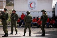 Russian soldiers are seen securing a Syrian Arab Red Crescent truck carrying aid at a checkpoint near Wafideen camp in Damascus, Syria, March 5, 2018. PHOTO BY REUTERS/Omar Sanadiki