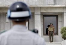 A North (R) and a South Korean army soldiers stand guard as members of the Group of Eminent Persons of the Comprehensive Nuclear-Test-Ban Treaty Organization visit the border village of Panmunjom that has separated the two Koreas since the Korean War, in Paju, South Korea, June 26, 2015. PHOTO BY REUTERS/Ahn Young-joon