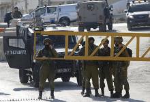 Israeli soldiers stand guard near the scene where a Palestinian, who the Israeli military said attempted to stab Israeli security forces with a screwdriver, after he was shot dead at a checkpoint near the West Bank city of Hebron, December 24, 2015. PHOTO BY REUTERS/Mussa Qawasma