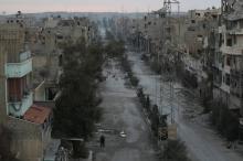 A man walks along a deserted street filled with debris in Deir al-Zor, eastern Syria, February 14, 2014. PHOTO BY REUTERS/Khalil Ashawi