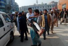 A man carries a student, who was injured during an attack by Taliban gunmen on the Army Public School, after he received treatment at a hospital in Peshawar, December 16, 2014. PHOTO BY REUTERS/Khuram Parvez