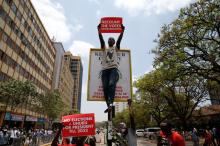 A supporter of Kenya's President Uhuru Kenyatta carries a placard as they demonstrate outside the Supreme Court in protest of the nullification of Kenyatta’s victory by the Supreme Court Judges in Nairobi, Kenya, September 19, 2017. PHOTO BY REUTERS/Baz Ratner