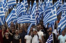 Supporters and members of extreme-right Golden Dawn party wave Greek national flags and shout slogans outside the Greek police headquarters in Athens