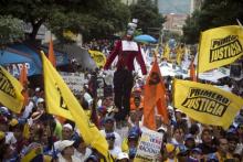 Opposition supporters chant and wave flags as a mannequin representing judge Susana Barreiros, who sentenced Lopez, holding a briefcase stuffed with dollars is paraded around during a rally in support of the political leaders in prison in Caracas, Venezuela, September 19, 2015. PHOTO BY REUTERS/Marco Bello