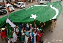 Supporters of civil rights group for transgender people, the Gender Interactive Alliance (GIA), dance and chant slogans as they pose with a national flag ahead of the Independence Day in Karachi, Pakistan, August 13, 2016. PHOTO BY REUTERS/Akhtar Soomro