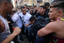 People surround a man suspected of stabbing Brazilian presidential candidate Jair Bolsonaro (not pictured) as he was campaigning in Juiz de Fora, Minas Gerais state, Brazil, September 6, 2018. PHOTO BY REUTERS/Felipe Couri/Minas Tribune