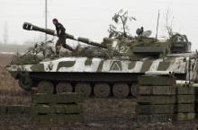 A member of the self-proclaimed Donetsk People's Republic forces walks on top of a self-propelled artillery gun during tactical training exercises in Donetsk region, Ukraine, February 4, 2016. PHOTO BY REUTERS/Alexander Ermochenko