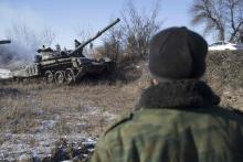 A man watches a tank of the separatist self-proclaimed Donetsk People's Republic Army manoeuvre near a checkpoint on the road from the town of Vuhlehirsk to Debaltseve, February 18, 2015. PHOTO BY REUTERS/Baz Ratner 