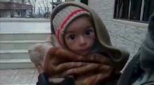 A toddler is held up to the camera in this still image taken from video said to be shot in Madaya on January 5, 2016. PHOTO BY REUTERS/Handout via Social Media Website