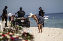 A tourist reads messages left at a makeshift memorial at the beach near the Imperial Marhaba resort, which was attacked by a gunman in Sousse, Tunisia, June 29, 2015. PHOTO BY REUTERS/Zohra Bensemra