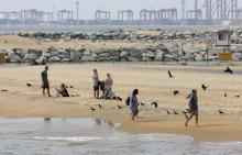 Tourists rest near the "Colombo Port City" construction site, backed by Chinese investment, in Colombo, February 8, 2016. PHOTO BY REUTERS/Dinuka Liyanawatte