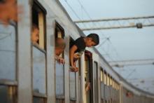 A young migrant hangs out from the window of a train while waiting to depart from the railway station in Tovarnik, Croatia, September 22, 2015. PHOTO BY REUTERS/Marko Djurica