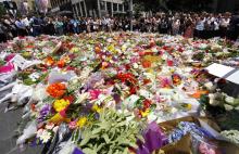 Members of the public look at thousands of floral tributes placed near the cafe in central Sydney, December 16, 2014 where hostages were held for over 16-hours. PHOTO BY REUTERS/David Gray