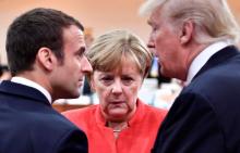 French President Emmanuel Macron, German Chancellor Angela Merkel and U.S. President Donald Trump confer at the start of the first working session of the G20 meeting in Hamburg, Germany, July 7, 2017. PHOTO BY REUTERS/John MacDougall