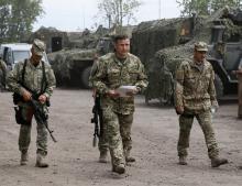 Newly-appointed Ukrainian Defence Minister Valery Heletey (C) walks with troops at a temporary base near the city of Slaviansk