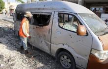 A municipality worker inspects a destroyed car at the site of a car bomb attack in Baghdad, July 13, 2015. PHOTO BY REUTERS/Khalid al-Mousily
