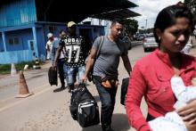 Venezuelans walk to show their passports or identity cards at the Pacaraima border control, Roraima state, Brazil, November 16, 2017. PHOTO BY REUTERS/Nacho Doce