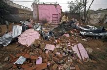 An Indian villager clears the debris from his house, which locals said was damaged by firing from the Pakistan side of the border, at Bainglad village in Samba sector, south of Jammu, January 6, 2015. PHOTO BY REUTERS/Mukesh Gupta