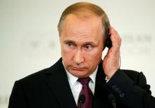 Russian President Vladimir Putin adjusts his headphones during a news conference with Laos' Prime Minister Thongloun Sisoulith (unseen) following the Russia-ASEAN summit in Sochi, Russia, May 20, 2016. PHOTO BY REUTERS/Sergei Karpukhin