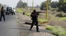 Armed Shi'ite volunteers from brigades loyal to radical cleric Muqtada al-Sadr, take their positions during a military advance in areas under the control of militants of the Islamic State, formerly known as the Islamic State in Iraq and the Levant (ISIL), on the outskirts of Samarra