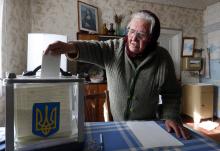 A local resident places her ballot into a mobile ballot box during a parliamentary election, at her home in Horodyshche near Chernihiv, October 26, 2014.PHOTO BY REUTERS/Stringer