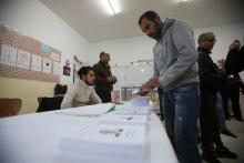 A voter receives ballots at a polling station during the presidential election in Algiers, Algeria, December 12, 2019. PHOTO BY REUTERS/Ramzi Boudina