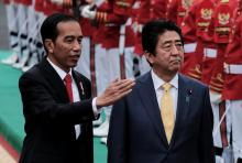 Indonesian President Joko Widodo (L) and Japanese Prime Minister Shinzo Abe inspect the honour guards during a welcoming ceremony at the Bogor Palace, West Java, Indonesia, January 15, 2017. PHOTO BY REUTERS/Beawiharta