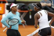 Serena Williams (L) of the U.S. talks with her sister Venus during a training session ahead of the first round of their Fed Cup World Group II tennis match against Argentina, in Buenos Aires, February 5, 2015. PHOTO BY REUTERS/Enrique Marcarian