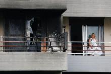 A woman speaks on the phone as she stands next to a burned apartment, following a wildfire at the village of Mati, near Athens, Greece, July 24, 2018. PHOTO BY REUTERS/Costas Baltas