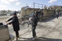 A man carries an injured woman in a site hit by what activists said were airstrikes carried out by the Russian air force in the rebel-controlled area of Maaret al-Numan town in Idlib province, Syria, January 9, 2016. PHOTO BY REUTERS/Khalil Ashawi