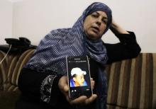 Suha, mother of Mohammed Abu Khudair, shows a picture of her son on her mobile phone at their home in Shuafat, an Arab suburb of Jerusalem