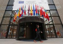A woman walks past the entrance of the European Council headquarters in Brussels