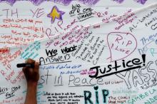 A woman writes on a message wall near the scene of the fire which destroyed the Grenfell Tower block, in north Kensington, West London, Britain, June 15, 2017. PHOTO BY REUTERS/Stefan Wermuth