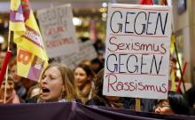 Women shout slogans and hold up a placard that reads "Against Sexism - Against Racism" as they march through the main railways station of Cologne, Germany, January 5, 2016. PHOTO BY REUTERS/Wolfgang Rattay