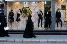 Shi'ite Muslim women walk past mannequins displaying black clothing in Nabatieh, southern Lebanon, October 17, 2015. PHOTO BY REUTERS/Ali Hashisho