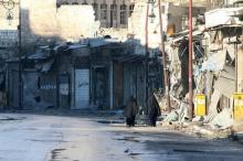 Women walk near damaged buildings in rebel-held besieged old Aleppo, Syria, December 2, 2016. PHOTO BY REUTERS/Abdalrhman Ismail