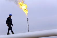 A worker walks on an oil pipeline at Khurmala oilfield on the outskirts of the city of Arbil, in Iraq's Kurdistan region