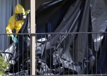A worker wearing a hazardous material suit puts up a tarp at the apartment unit where Thomas Eric Duncan, a Liberian citizen diagnosed with the Ebola virus, was staying in Dallas, Texas