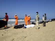 Public service workers bag bodies of migrants that drowned off Tripoli's coast