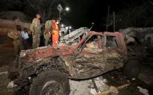 Somali government soldiers look at the wreckage of a car at the scene of an explosion in front of the presidential palace in the capital Mogadishu, September 21, 2015. PHOTO BY REUTERS/Feisal Omar