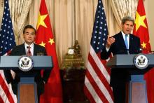 U.S. Secretary of State John Kerry (R) delivers remarks as China's Foreign Minister Wang Yi (L) looks on, before their meeting at the State Department in Washington, October 1, 2014. PHOTO BY REUTERS/Jonathan Ernst
