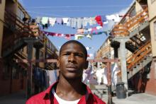 Youth worker Nathaniel Groep, 19, stands in front of flats outside his home in Mannenberg, a gang-ravaged township, in Cape Town