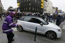 Belgian police react as a car runs through a road block before it hit and injured a woman on the street in the Brussels district of Molenbeek, Belgium, April 2, 2016. PHOTO BY REUTERS/Yves Herman