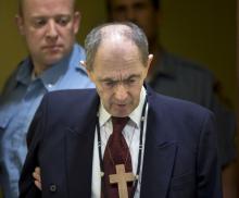 Zdravko Tolimir, a Bosnian Serb general convicted of genocide in the 1995 Srebrenica massacre, is escorted by U.N. security guards as he arrives in the courtroom of the Yugoslav war crimes tribunal who delivered its judgment in his appeal case in The Hague, Netherlands, April 8, 2015. REUTERS/Peter Dejong